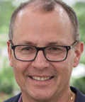 Man wearing glasses with a blurred green background