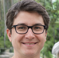 Person wearing glasses with a blurred green background